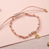 Pulseras Hilo Nudo - Laura Mano Hamsa rosa brilloso